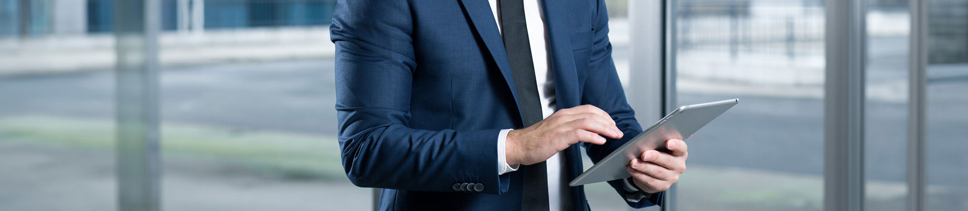 Obchodník hledící do tabletu a čekající až se s ním spojí právě Vaše firma